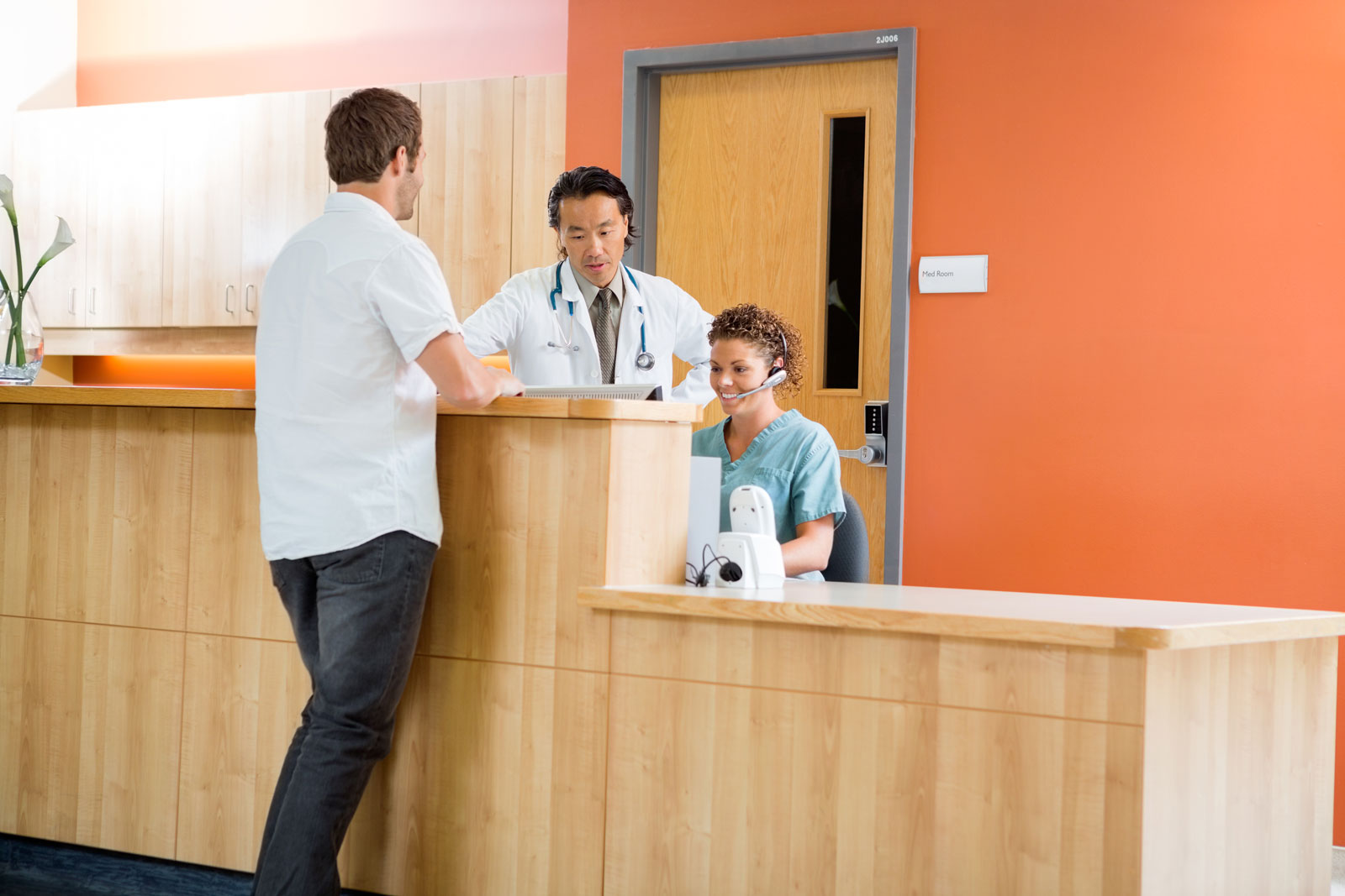 doctor-and-nurse-at-reception-desk-with-patient
