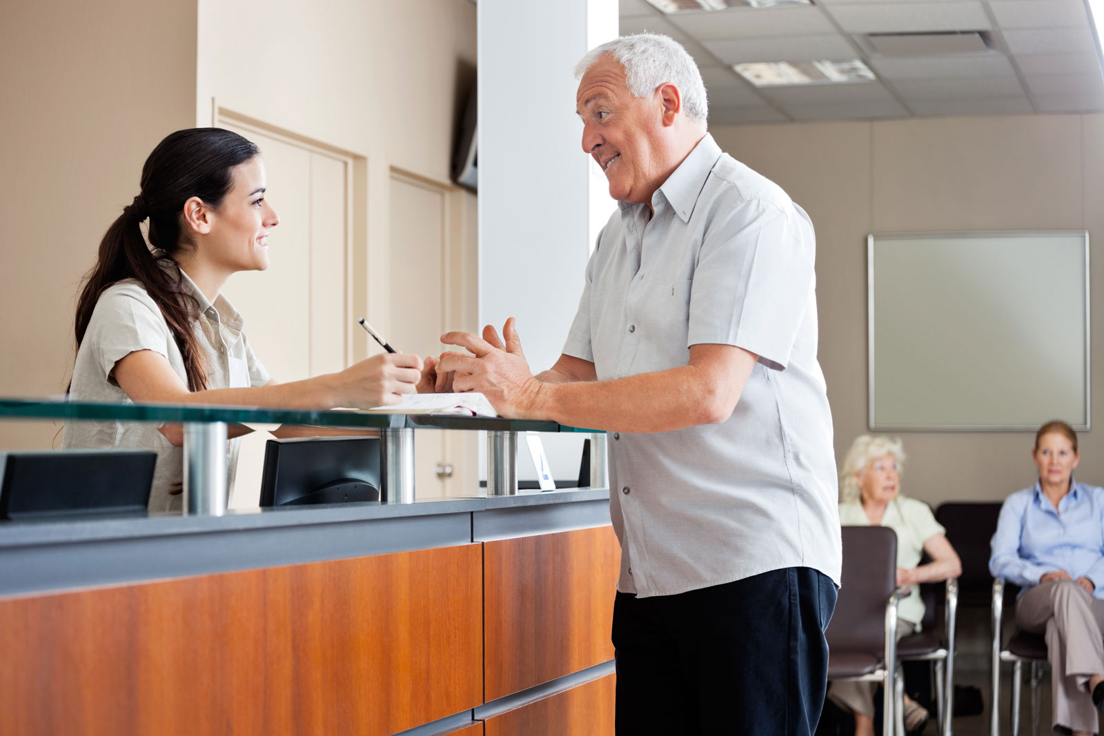 receptionist talking with older patient